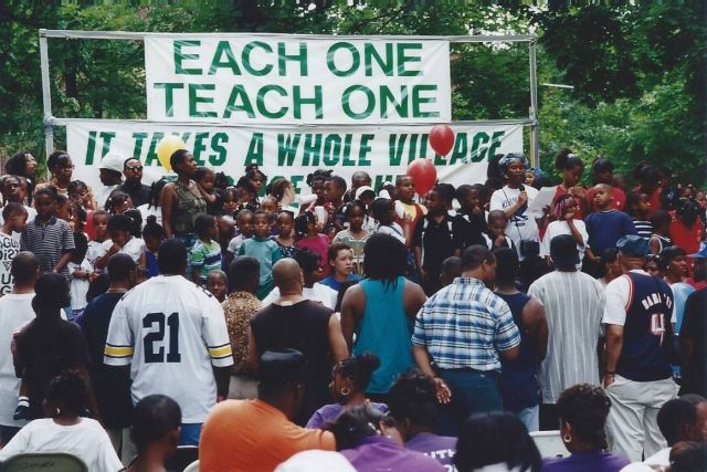 An outdoor rally showing 50 people of a crowd of 300 celebrating Keep Love Present.